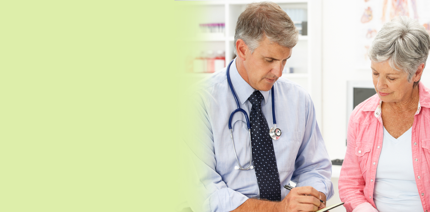 Male doctor showing an elderly female patient something 